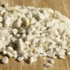 Heap Of Zeolite Stone On Wooden Background ZEOLITA - SACO 1KG